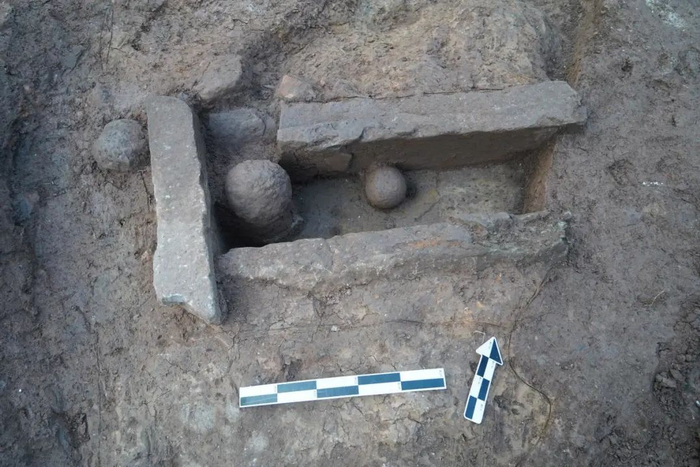 出土的排水沟及其内的礌石、夯头。重庆市文化遗产研究院供图