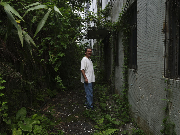 因无人管理，劳粤矪家门口野草遍布。摄影：翟星理