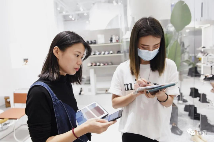 △&nbsp;9月25日，广州ARAapM服装批发市场里，卜桐在一家档口前报单拿货。