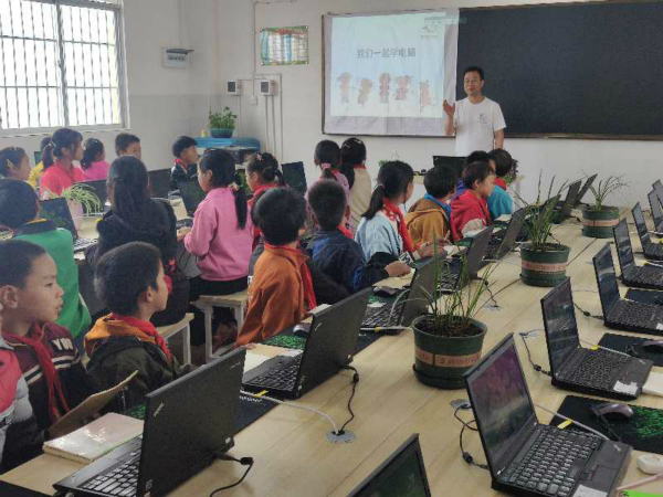 图说：2020年6月16日，云南广南县黑支果乡脚木塘小学的“爱传递”电脑教室内，张斌峰给四年级学生们上了一节电脑启蒙课。