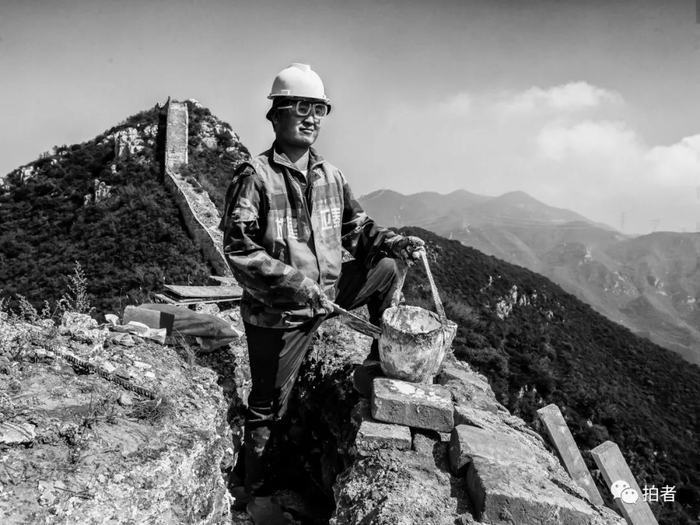 △ 9月26日，一位工人戴着防风镜站在90号敌台顶端，用白灰填充缝隙。