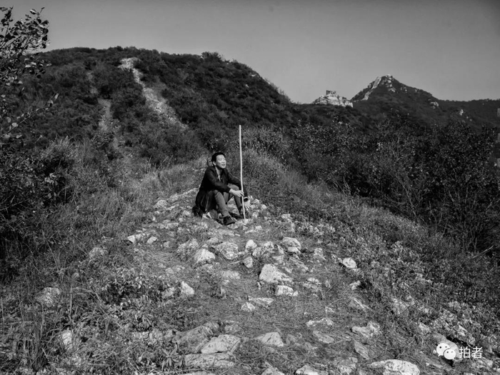 △ 9月26日，于海宽拄着木棍坐在北齐长城遗址上歇脚。