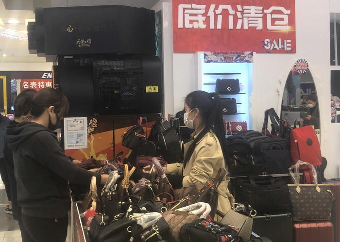 东安市场，一位顾客正在皮包柜台挑选商品。摄影/新京报记者 吴宁