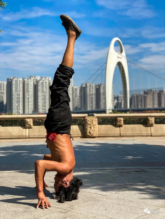 △ “倒立哥”。2019年11月30日，猎德大桥附近，一位流浪汉在练习倒立。