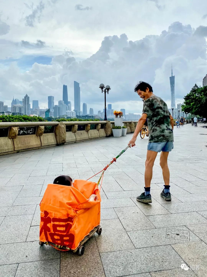 △ “福”。2020年6月2日，中大码头附近，笑容满面的老人拉着自制的拖车，一路小跑，他的孙子坐在“车”里咯咯直笑，车上的“福”字异常醒目。