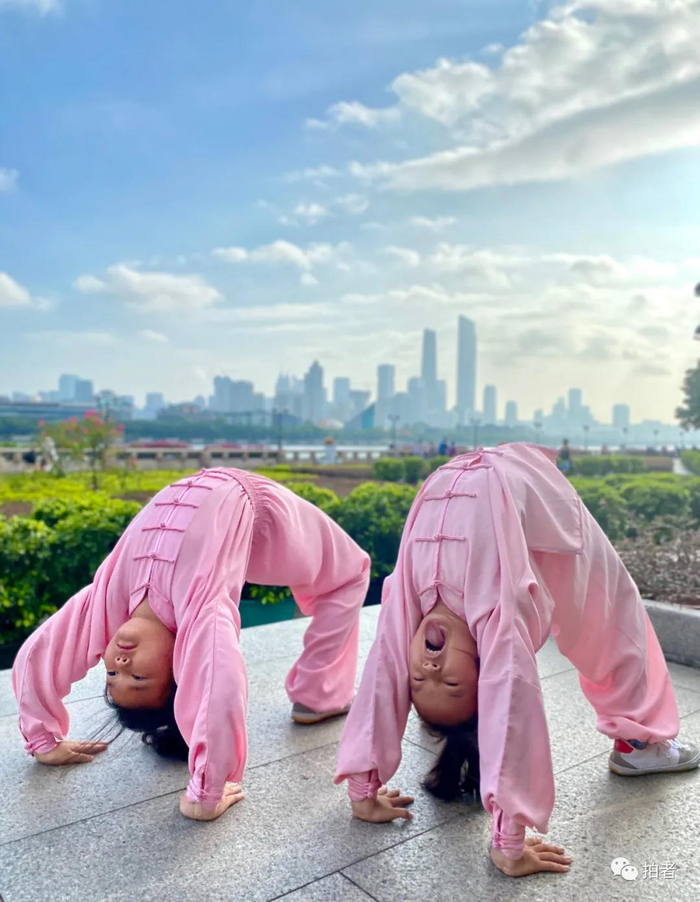 △ “少年强则国强”。2020年8月14日，中山大学北门附近，两位女孩在练习下腰。