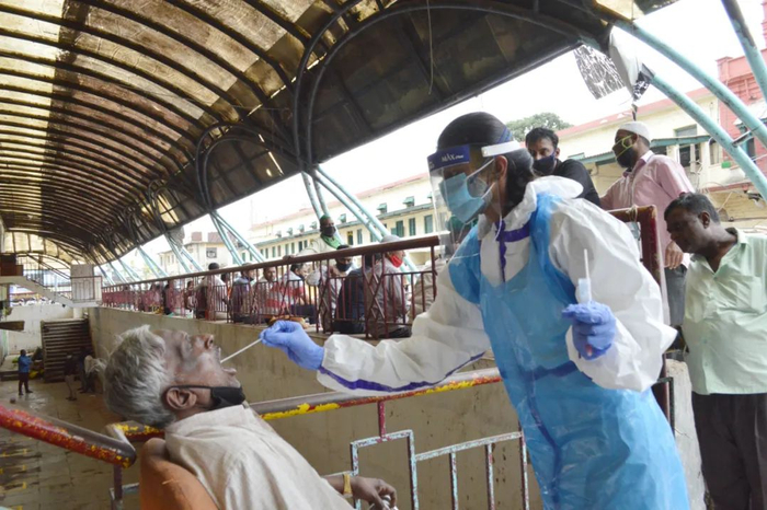 在印度班加罗尔，医务人员为市场商贩进行新冠病毒检测取样。图片来源：新华社