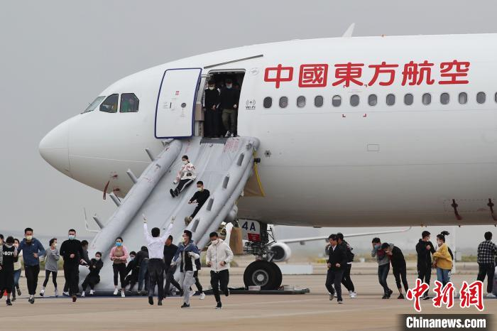 演习人员通过救生滑梯撤离飞机。　张亨伟 摄