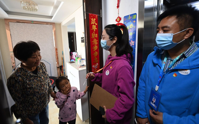 国奥村社区，普查员入户时须身着印有人口普查标志的服装，主动展示工作证件。摄影/新京报记者 陶冉