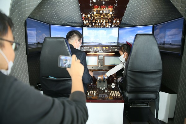 图说：现场观众走近飞机模拟驾驶舱。