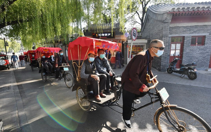 在乘坐三轮车游览的过程中，游客和车工均需佩戴口罩。新京报记者 李木易 摄