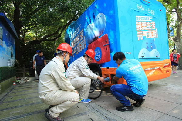 图说：国网上海电力工作人员为采用专门接口的流动餐车接通电源 采访对象供图（下同）