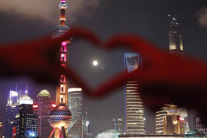 市民和游客在上海外滩滨江步道上拍照、赏月。视觉中国 图