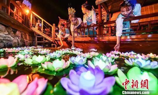 资料图：众多市民与游客乘坐竹筏将荷花灯放逐玉泉湖畔，点亮七彩心愿，共度中秋佳节。钟学满 摄