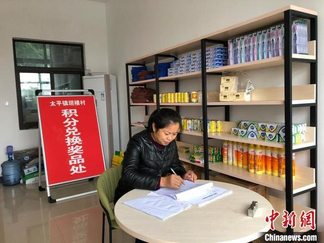 图为太平镇垣楼村党支部书记周云芬整理积分兑换薄。 钟旖 摄