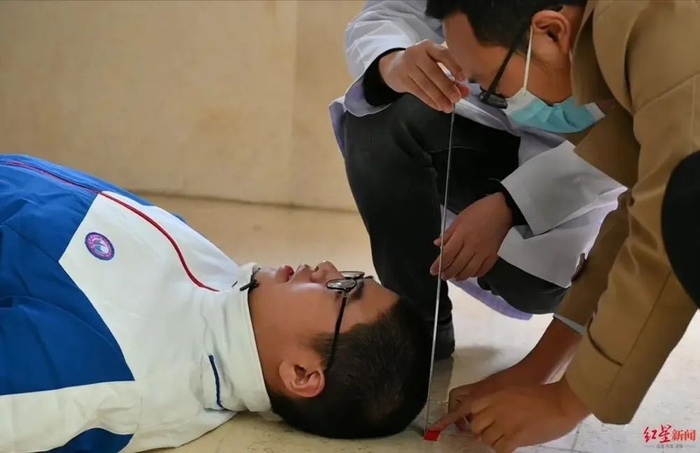 △工作人员为小宇测量躺高