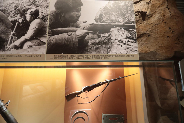 展出的照片和枪支。新京报记者 王嘉宁 摄