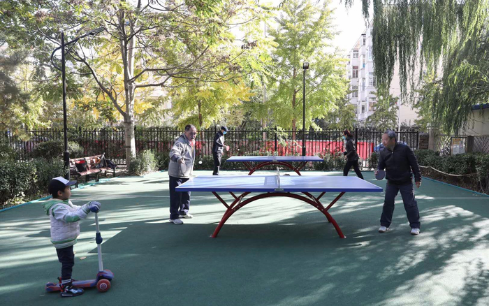 朝阳区奥运村街道科学园南里六区，小区改造后，居民在体育运动休闲区域打乒乓球。摄影/新京报记者 王飞