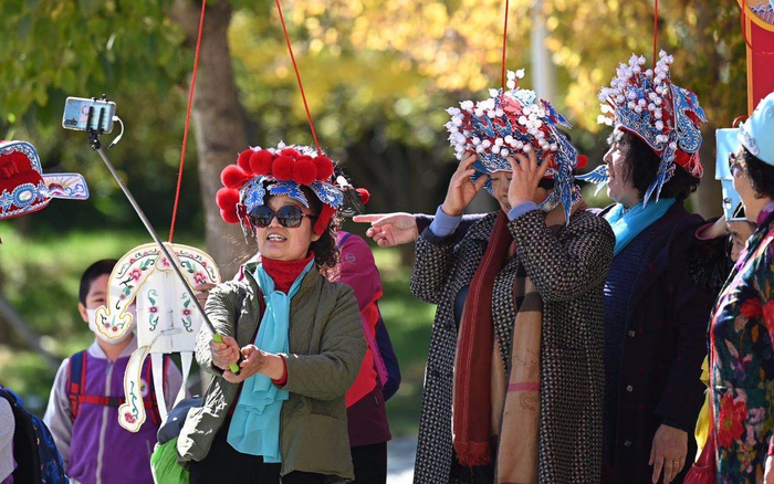 北京园博园内，观众体验戏装戏服并自拍留念。摄影/新京报记者 陶冉