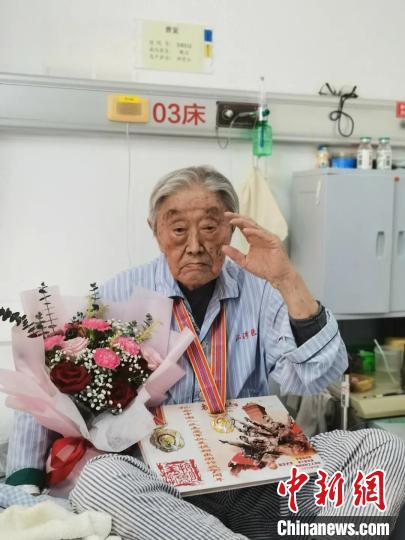 病榻上的曹宠收到纪念章。复旦大学供图