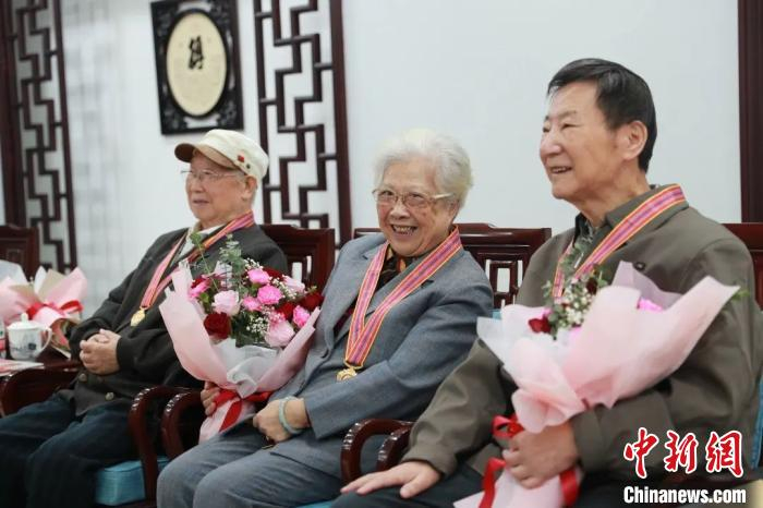 谢大业 、袁美英和林相荣佩戴了纪念章。复旦大学供图