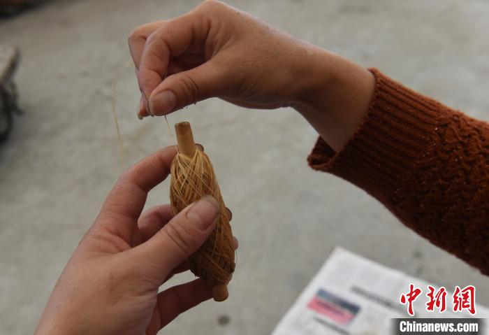 图为工作人员正在挽麻团。　周毅 摄