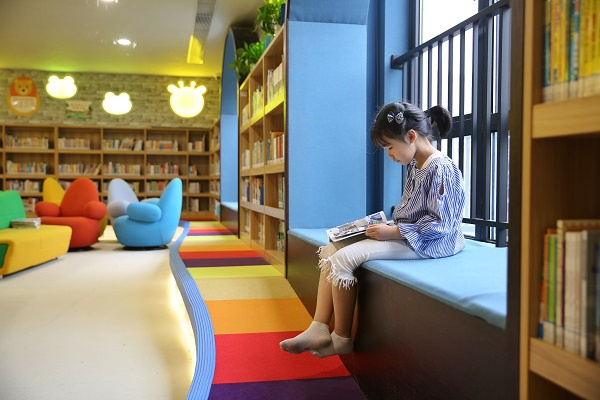 图说：布置温馨的亲子阅览室内，孩子在认真看书。周馨 摄