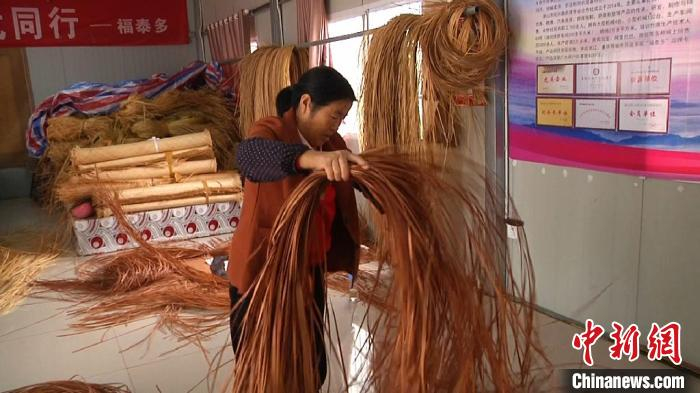 扶贫车间里，一位编工正在整理篾条。　刘鸿鹤 摄