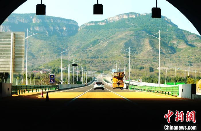 驾车在“济泰高速”上行驶，穿越隧道后，秋色“迎”面而来。　沙见龙 摄