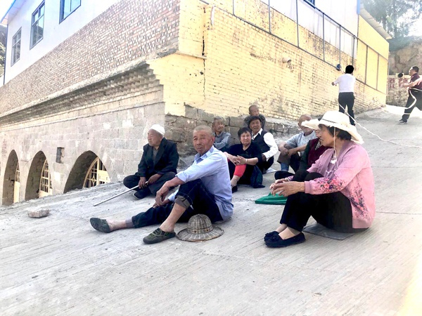 陕西榆林佳县干完活的花甲老人在村口席地而坐休息 张斌 摄