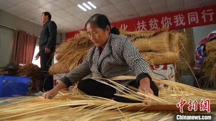 胡金环正在扶贫车间里编织舒席。刘鸿鹤 摄