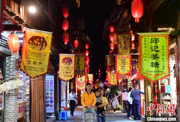 图为10月27日晚，中国历史文化名街福建长汀店头街，古色古香的牌楼和老店铺吸引众多市民和游客前来游玩。　张斌 摄