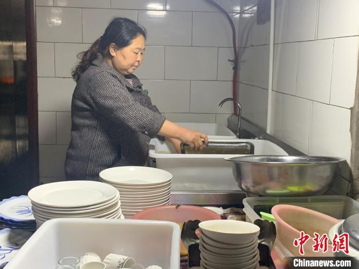 图为白秀花刚送走一波客人，正在自家农家乐后厨洗碗。　奥蓝 摄