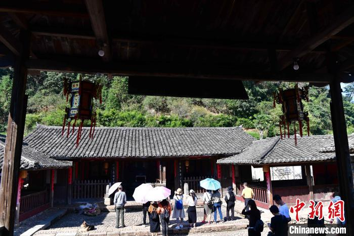 图为游客在培田村观赏古民居。　张斌 摄