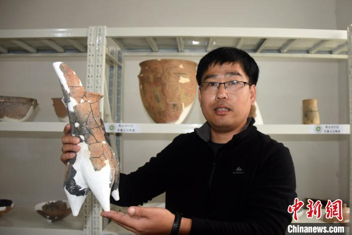 张东博士展示介绍禹会村遗址出土的一件代表性文物。　孙自法 摄