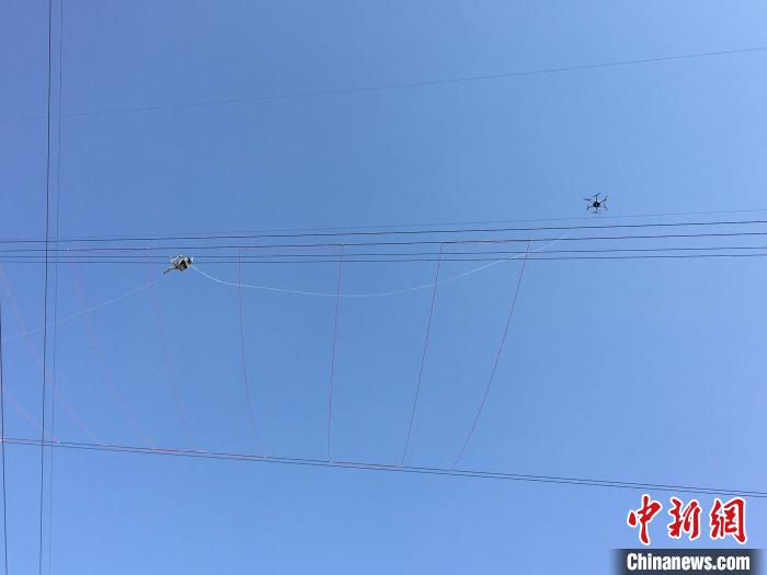     图为青海主电网首次使用无人机“穿针引线”配合输电项目施工。　张晗　摄
