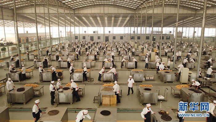 　　伽师县馕产业园上百个烤馕机正在同时烤制窝窝馕（无人机照片）。新华网记者 焦鹏 摄