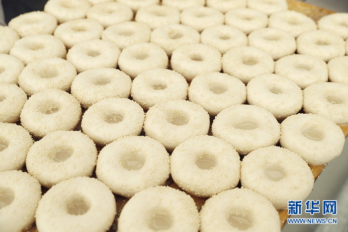 　　这是湿漉漉的窝窝馕馕坯，在馕坯上洒水为的是粘住白芝麻。新华网记者 焦鹏 摄