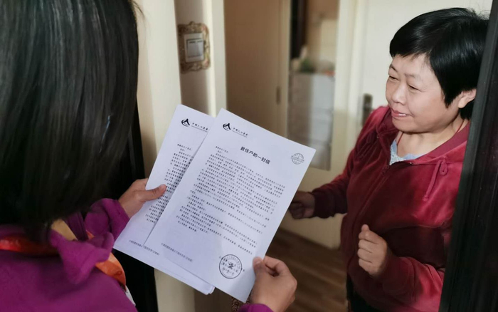 普查员在摸底期间向居民发放《致住户的一封信》并进行普查告知。北京市人口普查办公室供图