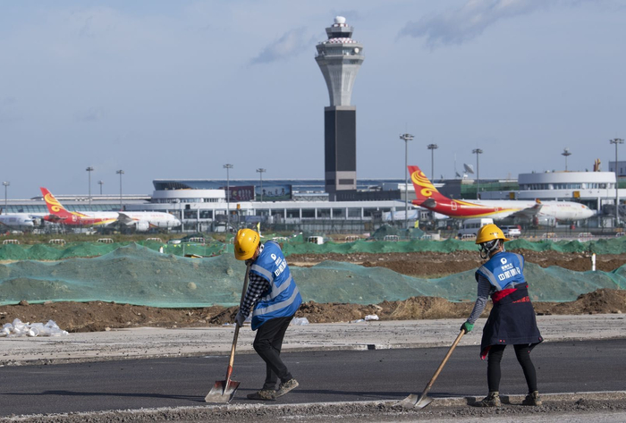 施工人员正在检查西跑道道面摊铺情况。摄影/新京报记者 陶冉