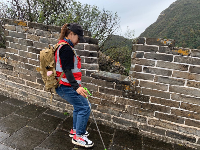 雨后长城湿滑，刘红岩扶着墙壁小心行进。新京报记者 倪伟 摄
