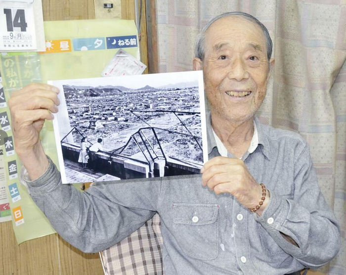 手持自己照片的川上清 图源：共同社