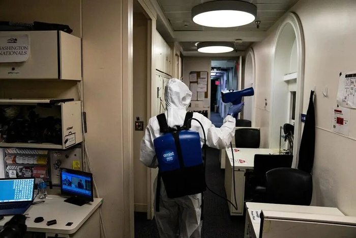 本周，包括简报室在内的白宫部分地区就像是一个危险区域。身着全套防护服的工作人员在对公共场所进行消毒。图源：《纽约时报》