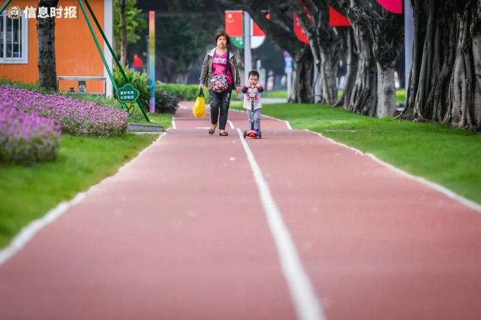 市民带着小朋友在公园配备的红色缓跑径上漫步。信息时报记者 胡瀛斌 摄