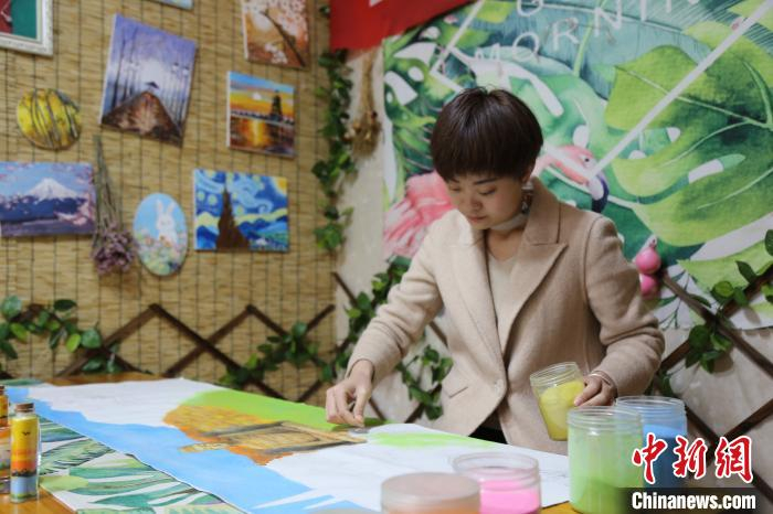 朱霞用沙画演绎“最美家乡”。　王惠林 摄