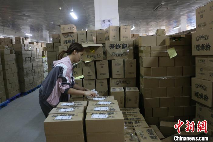 广西沪桂食品集团有限公司员工，给打包好的螺蛳粉贴快递单。　林馨 摄