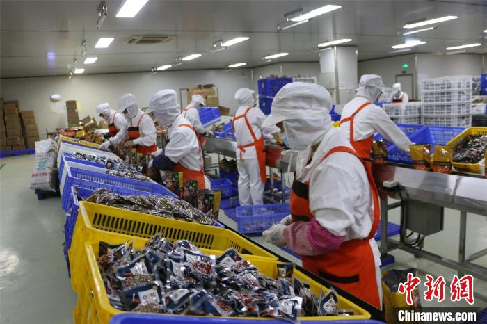 工人忙着打包袋装螺蛳粉。　林馨 摄