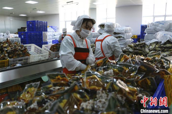 工人忙着打包袋装螺蛳粉。　林馨 摄