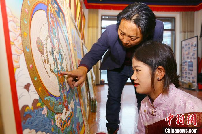 唐卡画师尕藏克智正在辅导卓玛才让。　高展 摄