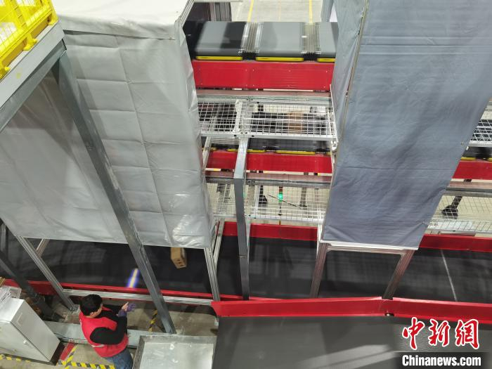 图为经过自动识别编码后，大小件、易碎易损甚至异常货品被运输至不同的分拣流水线上。　崔琳 摄